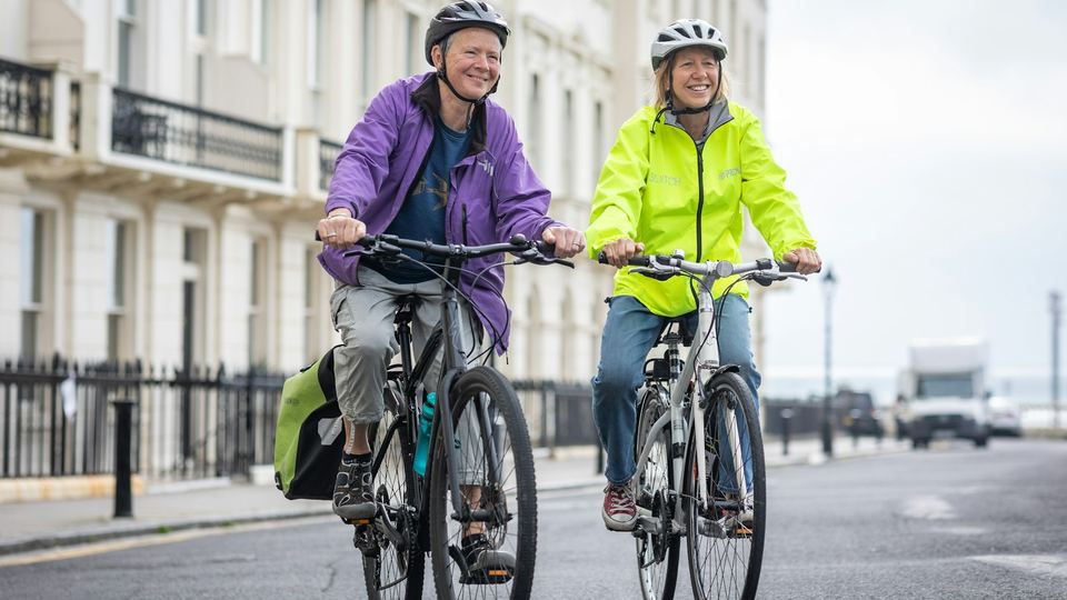 A couple cycling along a seafront road
